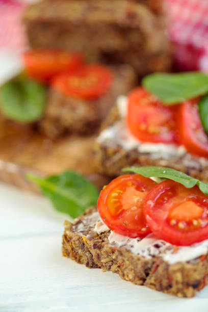 Full-Grained, glutenfree bread with almond cream cheese, tomatoes and spinach – vegan, glutenfree