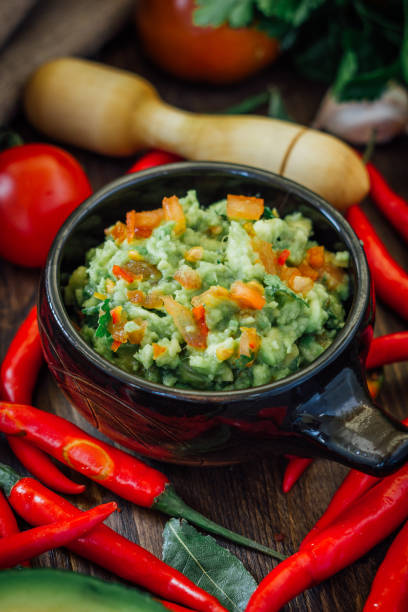 istock Guacamole dip with ingredietns in black ceramic bowl. 667602978