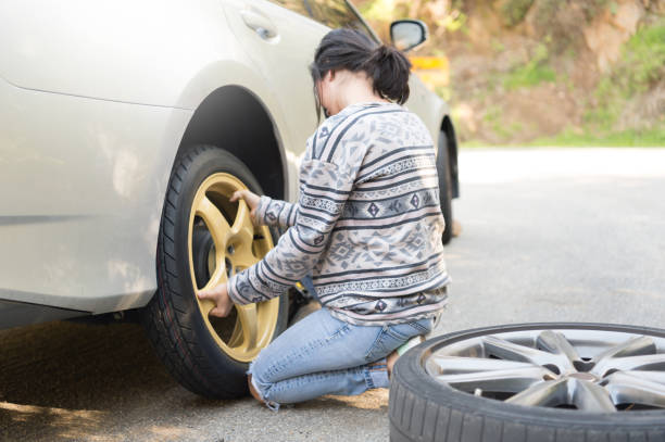 istock Young Women Changing A Flat Tire 667607548