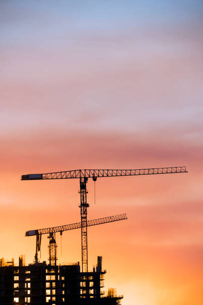 istock Backlit Industrial Construction Cranes with Sunset Sky Miami Florida 667610340