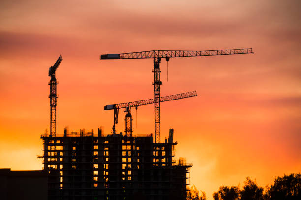 istock Backlit Industrial Construction Cranes with Sunset Sky Miami Florida 667610522