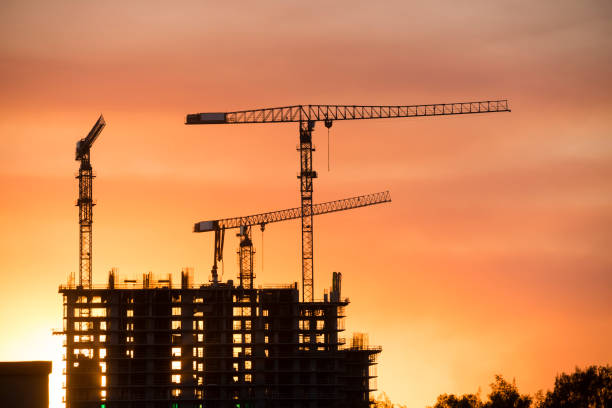 istock Backlit Industrial Construction Cranes with Sunset Sky Miami Florida 667610696