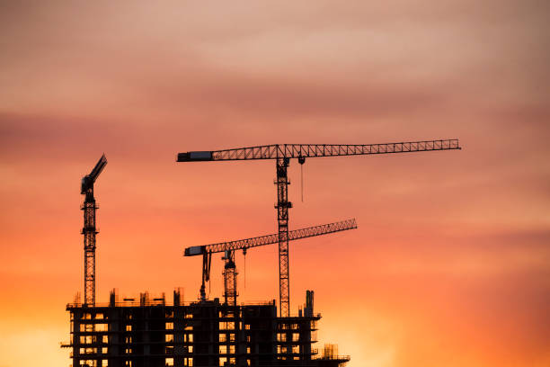 istock Backlit Industrial Construction Cranes with Sunset Sky Miami Florida 667610890
