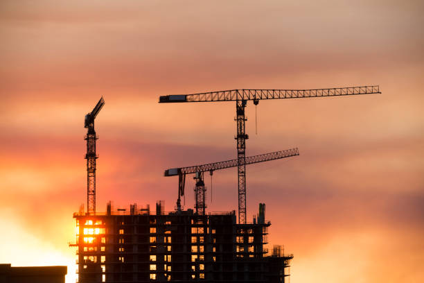 istock Backlit Industrial Construction Cranes with Sunset Sky Miami Florida 667611116