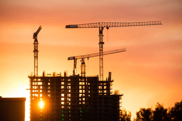 istock Backlit Industrial Construction Cranes with Sunset Sky Miami Florida 667611362