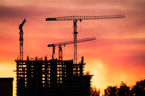 istock Backlit Industrial Construction Cranes with Sunset Sky Miami Florida 667613574