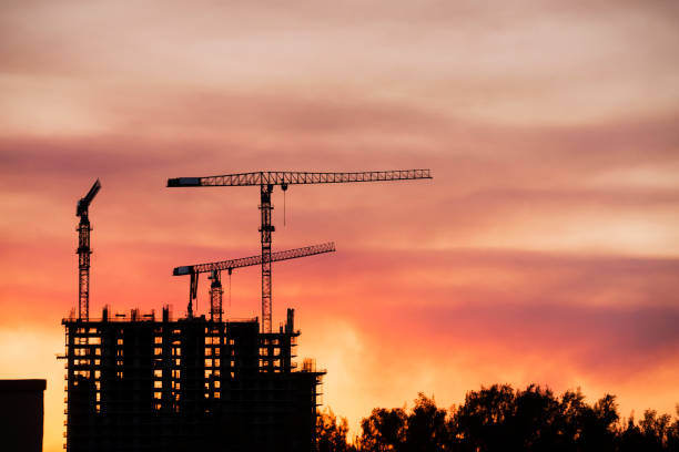 istock Backlit Industrial Construction Cranes with Sunset Sky Miami Florida 667614034