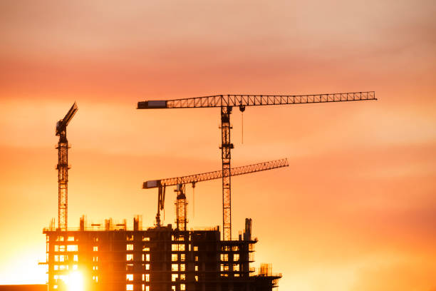 istock Backlit Industrial Construction Cranes with Sunset Sky Miami Florida 667614166