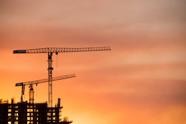 istock Backlit Industrial Construction Cranes with Sunset Sky Miami Florida 667614280
