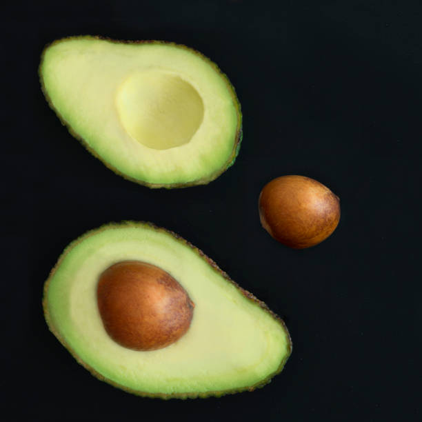istock cut avocados on a dark background 667614596