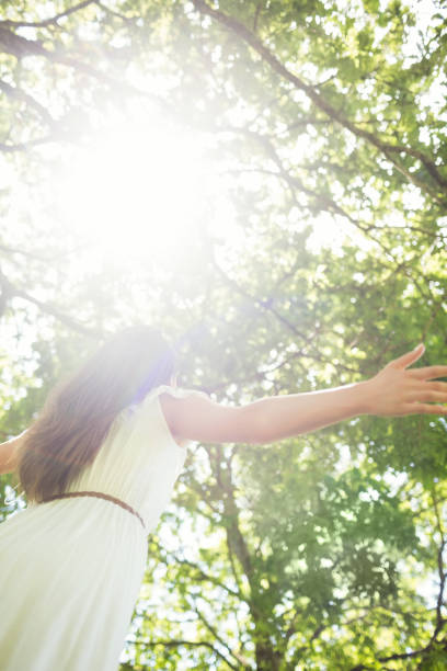 istock Low angle view of woman against bright sunlight 667618518