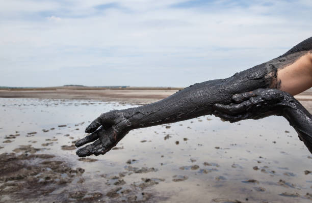 istock Smearing black healing mud on the arm. 667620614