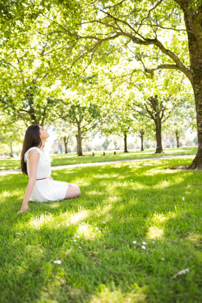 istock Side view of woman sitting on grassland 667621502