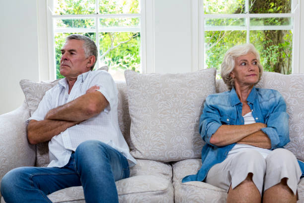 istock Annoyed senior couple looking away while sitting on sofa 667628748