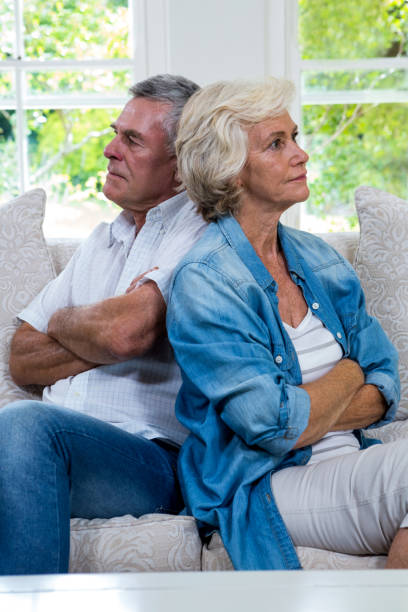 istock Annoyed senior couple sitting back to back on sofa 667628824