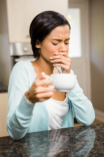 istock Frowning woman with toothache holding cup 667628858