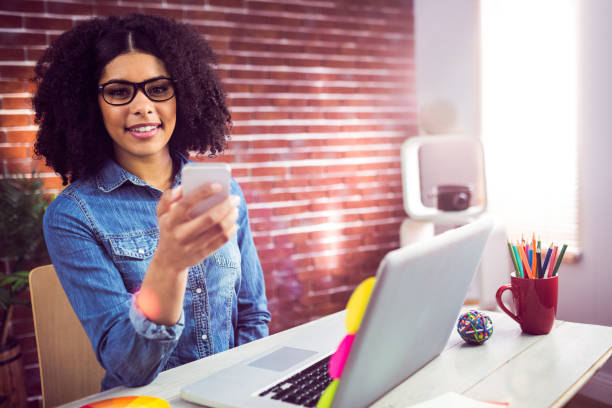 istock Casual businesswoman using her smartphone and smiling at camera 667630236