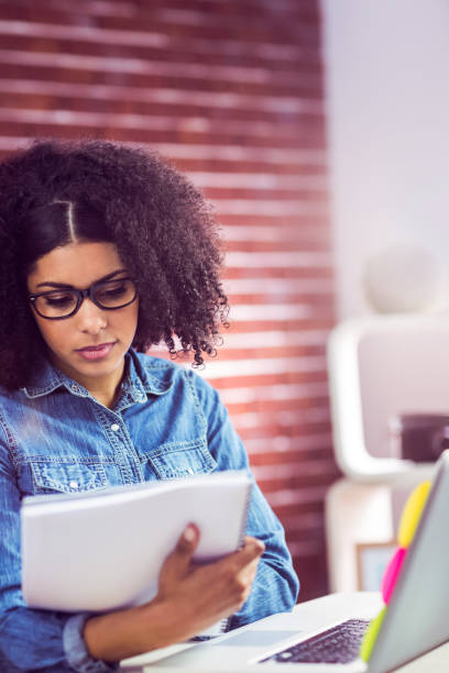 istock Casual businesswoman looking at reports 667632334