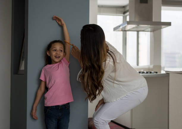 istock Happy mother measuring her daughter at home 667633200