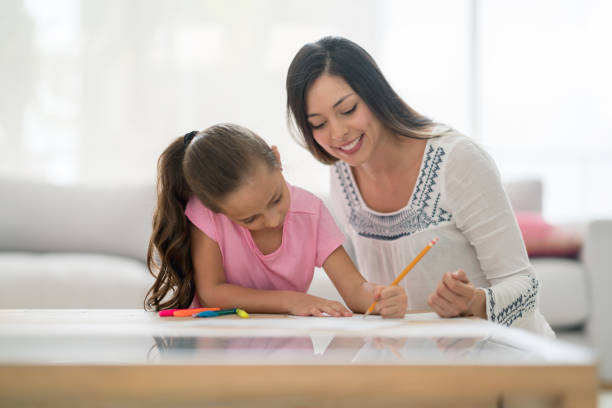 istock Happy girl coloring at home with her mother 667633232