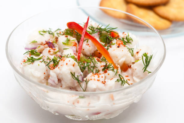 Peruvian ceviche preparation : White fish Peruvian ceviche served in a transparent bowl with crackers