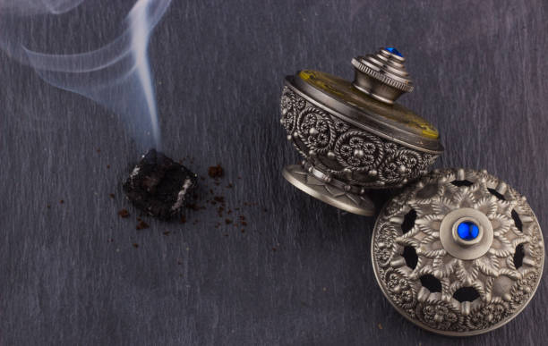 istock Silver Oriental Artistic Arabian Oud Perfume / Arabian Oud Perfume with Oud Scented Wood burned in the background with Scented Smoke in the Air 667638968