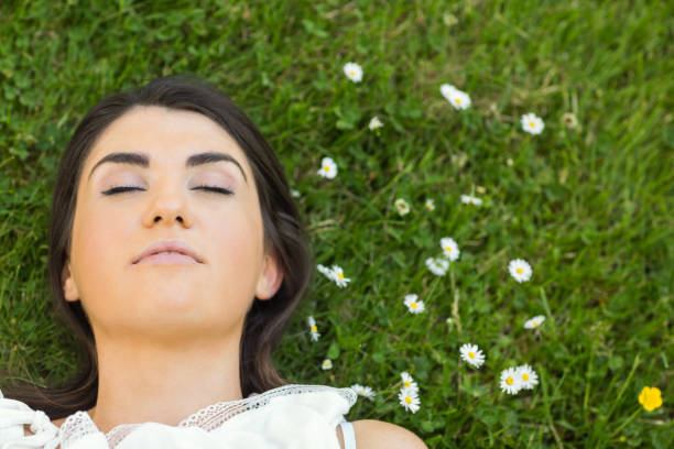 istock Beautiful young woman relaxing on grassland 667646426