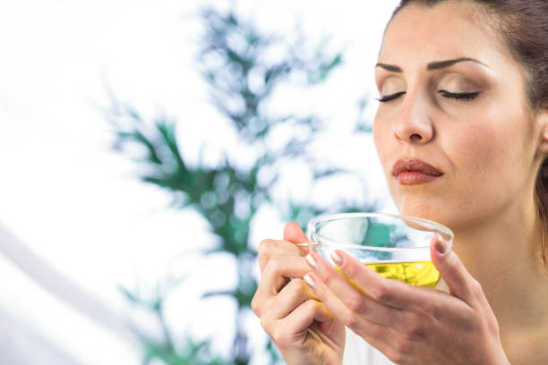 istock Woman smelling herbal tea with eyes closed 667649998