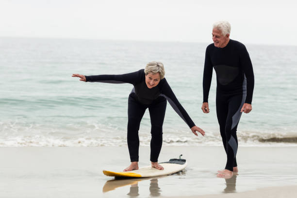 istock Senior man teaching woman to surf 667652638