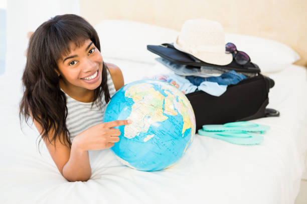 istock Casual smiling woman touching globe on the bed 667652694