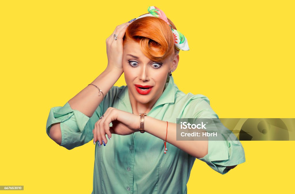 Woman being late. Closeup portrait headshot view stressed young attractive beautiful businesswoman checking the time being late to a business meeting to a rendez-vous, date isolated yellow background Checking the Time Stock Photo