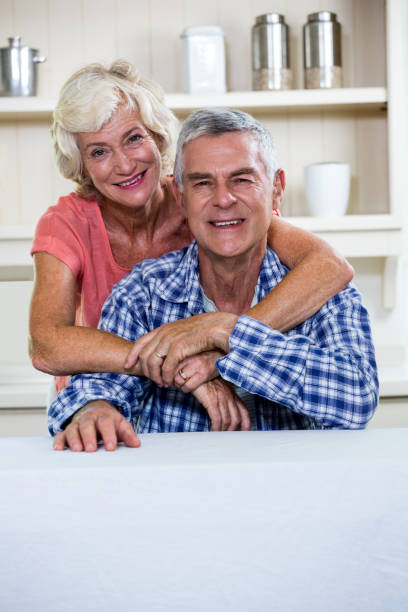 istock Happy senior couple hugging in kitchen at home 667657588