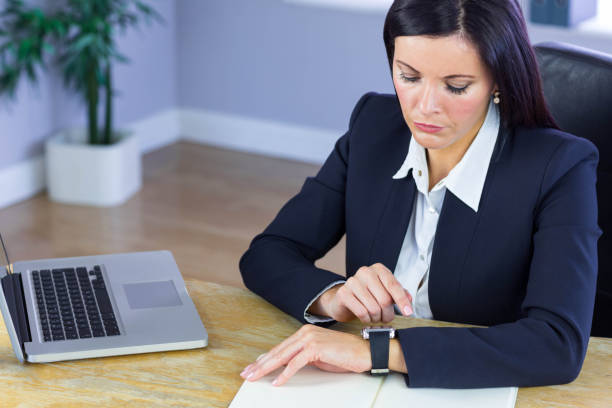 istock Businesswoman using her smartwatch at desk 667671172
