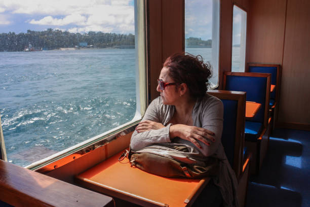 istock Thinking woman looking on the sea from ferry boat window 667672816