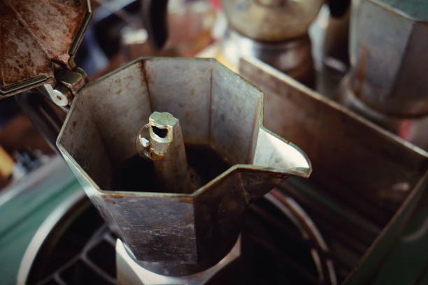 moka pot cafetera tradicional italiana con café caliente - foto de stock