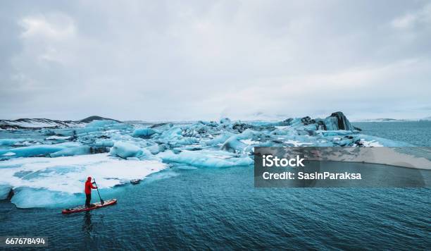 Photo libre de droit de Belle Vue Sur Le Lagon Glacier Des Icebergs Avec Un Type De Paddle Board Réchauffement Planétaire Et Concept De Changement Climatique banque d'images et plus d'images libres de droit de Explorateur