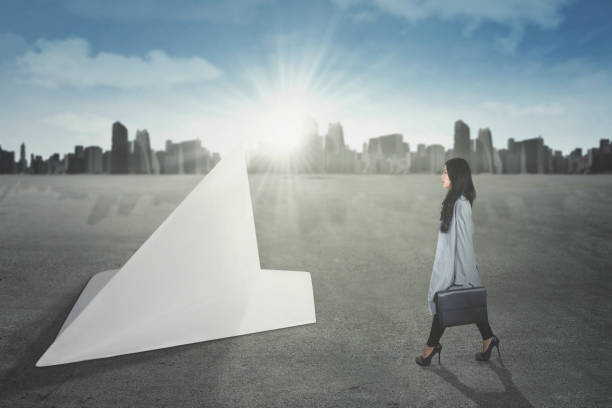 istock Woman walking toward paper airplane 667678910