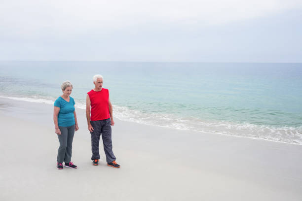 istock Senior couple standing on the beach 667682298
