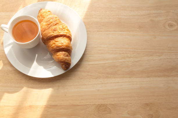 istock croissant and tea for breakfast with copy space 667682542