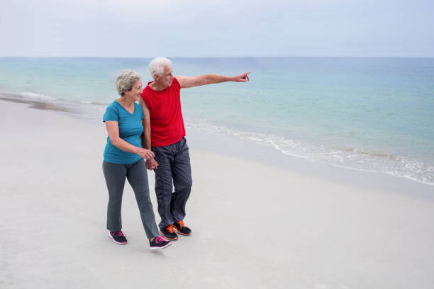 istock Senior couple talking and walking on the beach 667682646