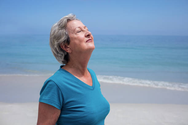 istock Senior woman with eyes closed on the beach 667685116