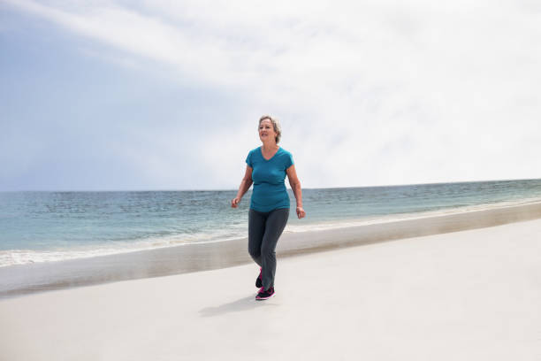 istock Senior woman jogging on the beach 667685234