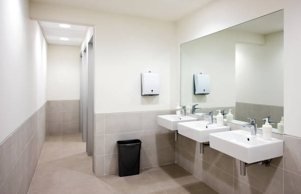 Public bathroom sinks Empty public bathroom with white sinks and wide wall mirror, air hand drier and black recycle bin public restroom photos stock pictures, royalty-free photos & images