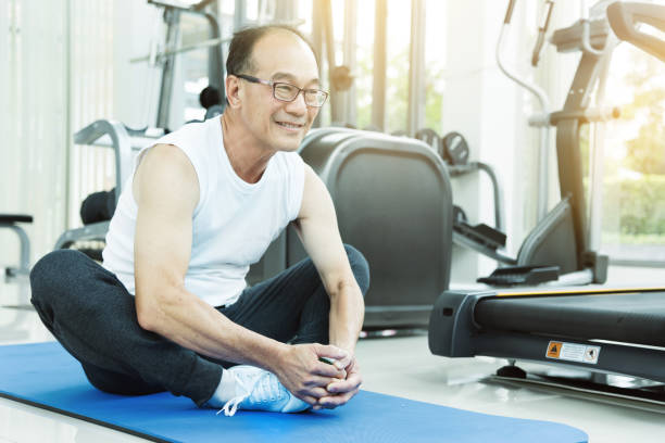 istock Asian senior man Stretching before workout at the gym. copy space. 667690462