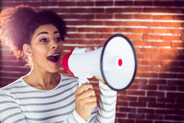 istock Young woman using her megaphone in the light 667693320