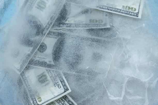 100 ドルの凍結を溶かします。 - frozen currency finance ice ストックフォトと画像