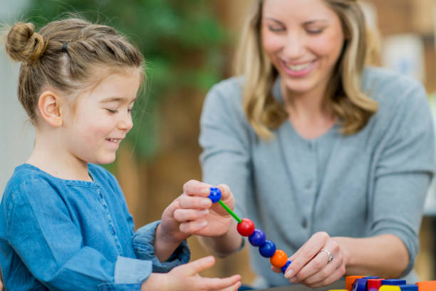 istock Girl And Teacher Happily Playing With Blocks 667698060