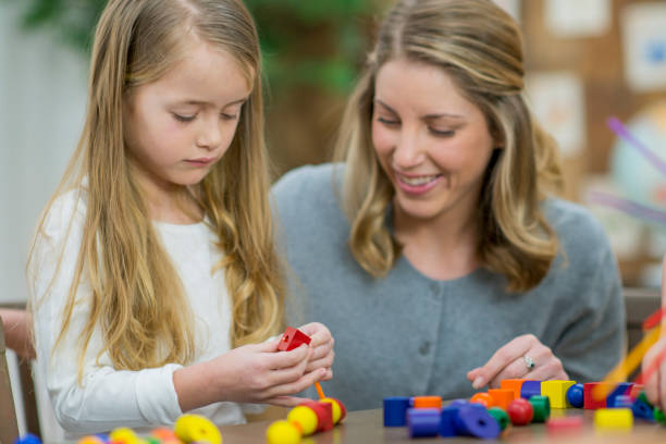 istock Girl And Teacher Playing With Blocks 667698102