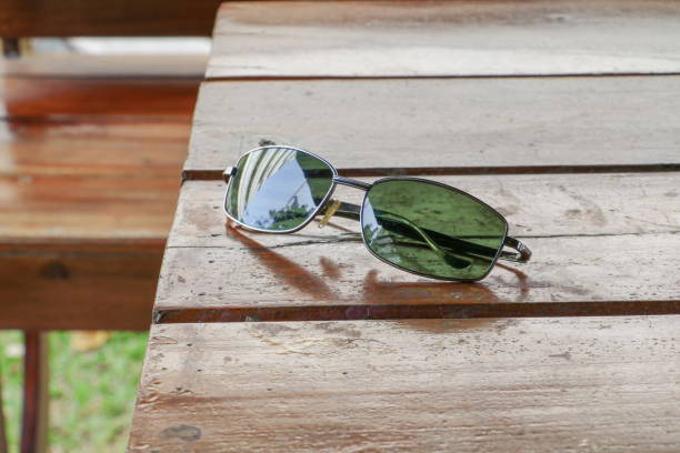 istock Black sunglasses on a wooden table. 667700846