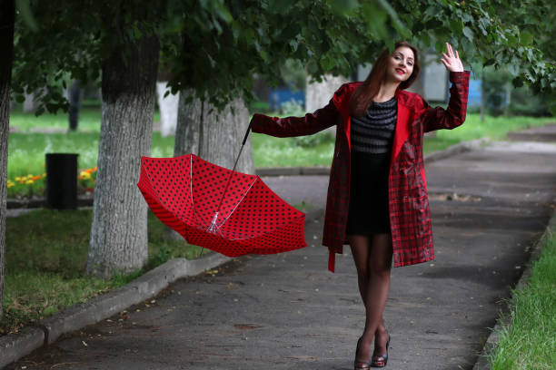 istock woman in a raincoat and an umbrella 667704450